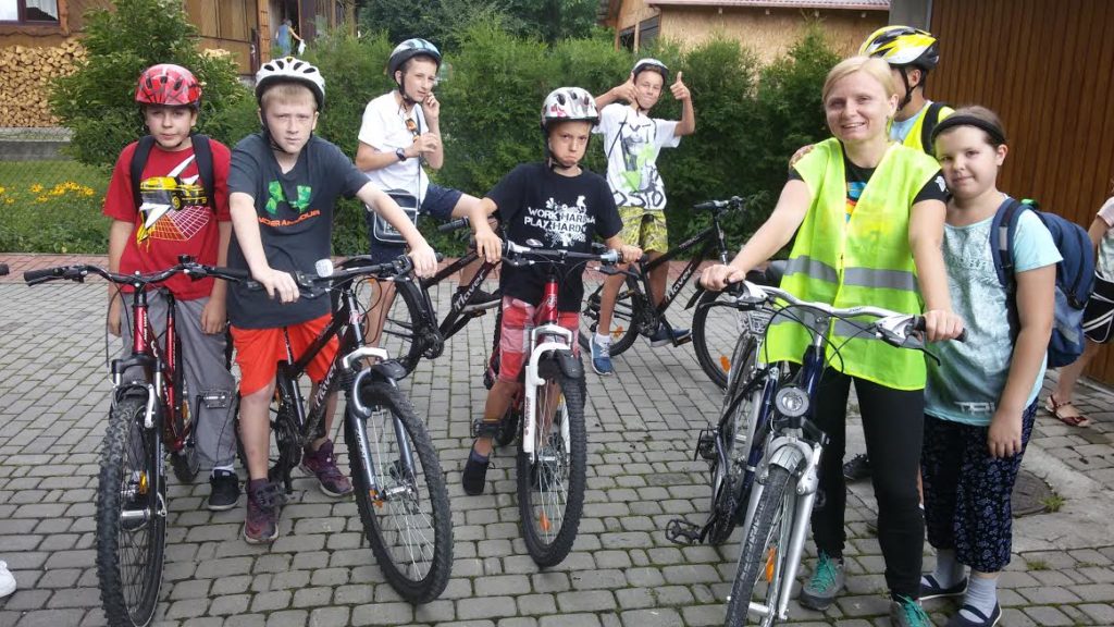 Grupa dzieci z instruktorem na rowerach