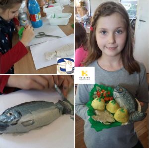 Dziewczynka maluje rybe i warzywa wykonane z masy solnej